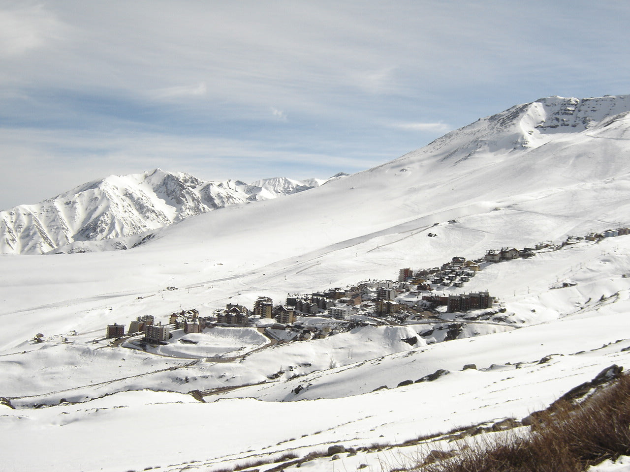 Snow-covered mountain landscape with a small village at the base
