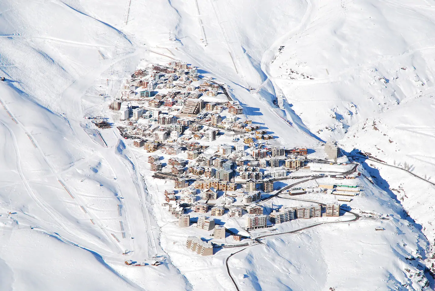 Snow-covered mountain village with ski lifts and slopes