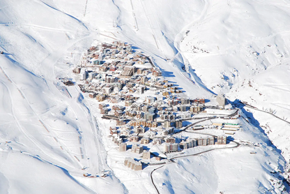 Snow-covered mountain village with ski lifts and slopes