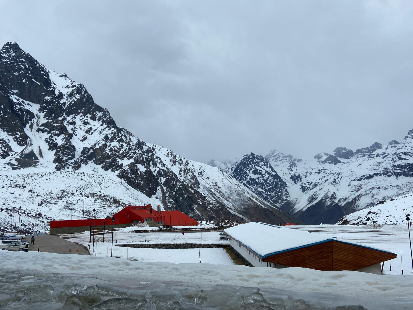 Snow-covered mountain landscape with red and blue buildings.