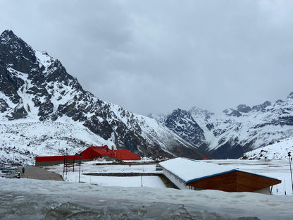 Snow-covered mountain landscape with red and blue buildings.