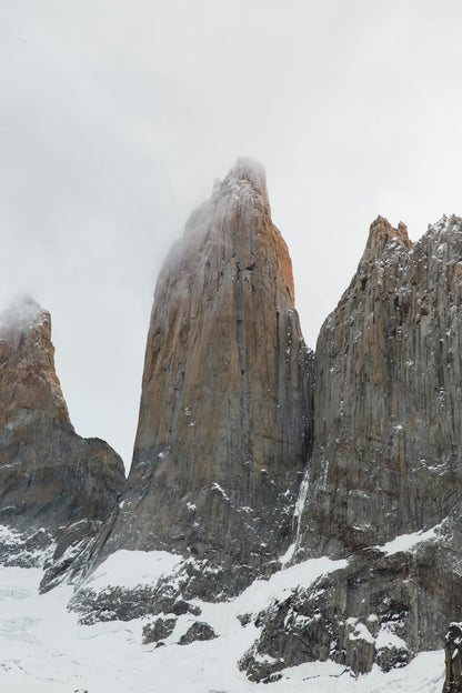 Snow-covered mountain peaks under a cloudy sky