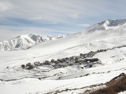 Snow-covered mountain landscape with a small village at the base